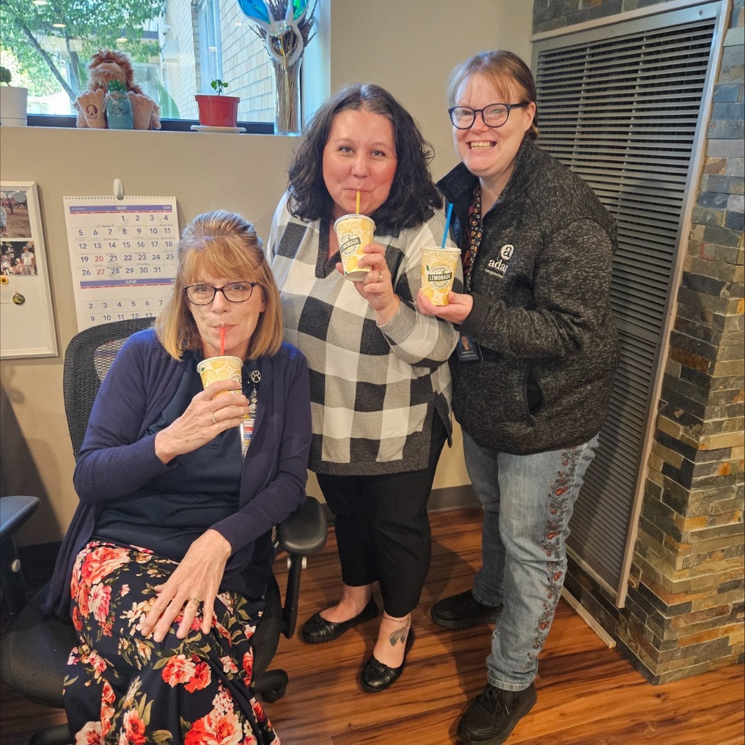 Primary Care Lemonade Day: Three Adapt Integrated Health Care employees enjoy lemonade drinks while posing and smiling in an office setting.