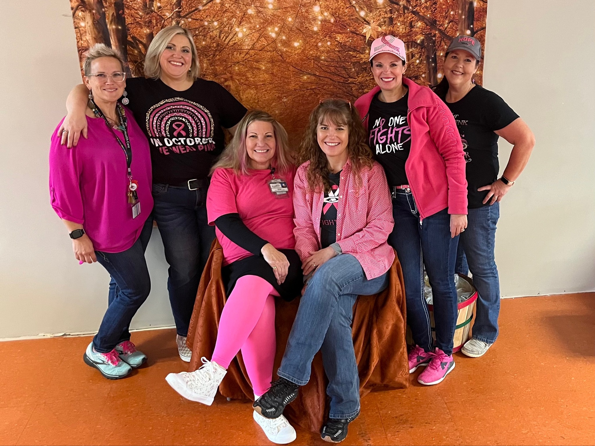 Breast Cancer Awareness Celebration: Six Adapt Integrated Health Care employees dressed in pink, posing together to support breast cancer awareness, with a festive backdrop.