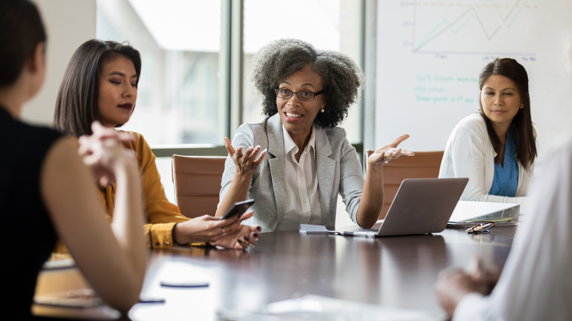 A diverse group of board members actively engaged in discussion, exemplifying leadership and collaboration at a board meeting.